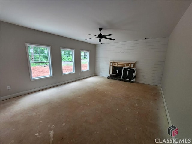 350 Discovery Trl, Athens, GA 30605 - unfurnished living room featuring concrete floors, ceiling fan, a brick fireplace, and wood walls