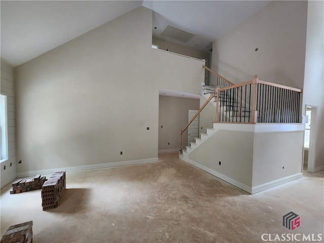 375 Discovery Trl, Athens, GA 30605 - unfurnished living room with high vaulted ceiling, concrete flooring, stairway, and baseboards