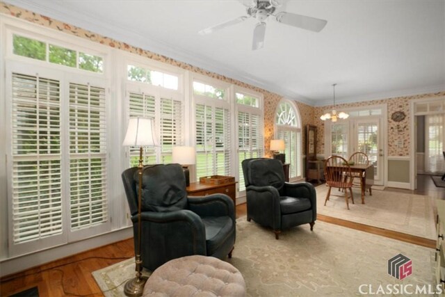 416 Mcdaniel St, Monroe, GA 30655 - living area with crown molding, a chandelier, wood finished floors, wainscoting, and wallpapered walls