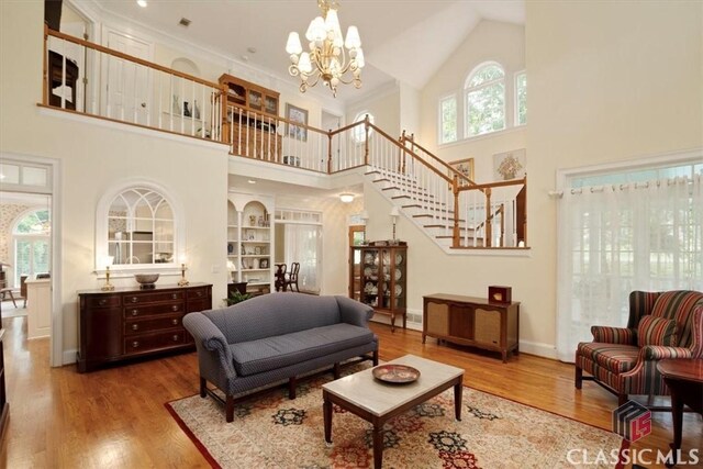 416 Mcdaniel St, Monroe, GA 30655 - living area with a high ceiling, stairs, a chandelier, wood finished floors, and baseboards