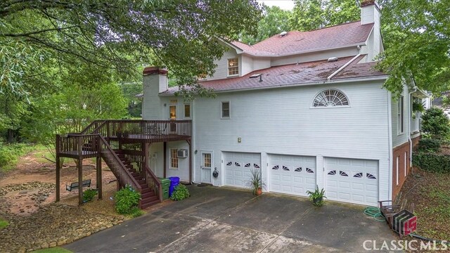 416 Mcdaniel St, Monroe, GA 30655 - rear view of house with a chimney, an attached garage, concrete driveway, and a deck