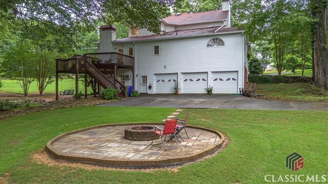 416 Mcdaniel St, Monroe, GA 30655 - back of house featuring a chimney, an attached garage, stairs, and a fire pit