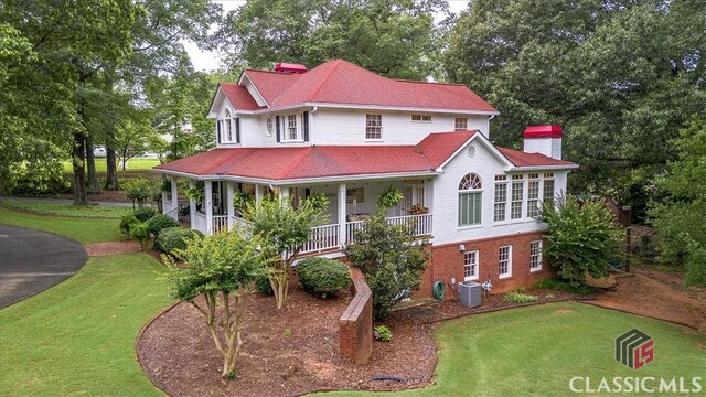 416 Mcdaniel St, Monroe, GA 30655 - view of front of property featuring a chimney, a front yard, a porch, central AC, and view of scattered trees