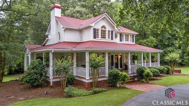416 Mcdaniel St, Monroe, GA 30655 - farmhouse-style home with covered porch, a chimney, roof with shingles, and a front lawn