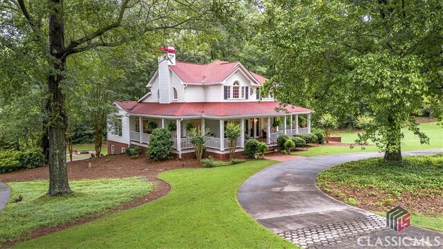 416 Mcdaniel St, Monroe, GA 30655 - farmhouse inspired home with curved driveway, covered porch, a front yard, and a chimney