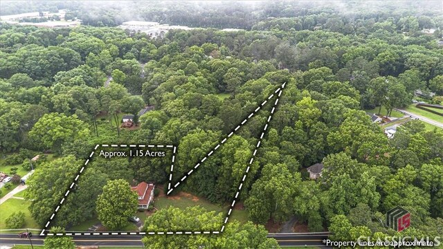 416 Mcdaniel St, Monroe, GA 30655 - aerial view of property and surrounding area with property boundaries highlighted and a heavily wooded area