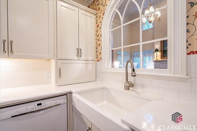 416 Mcdaniel St, Monroe, GA 30655 - kitchen featuring dishwasher, a sink, wallpapered walls, decorative backsplash, and light stone countertops