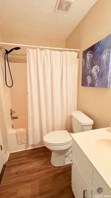 210 Big Oak Cir, Athens, GA 30605 - bathroom featuring wood finished floors, vanity, toilet, shower / tub combo, and a textured ceiling