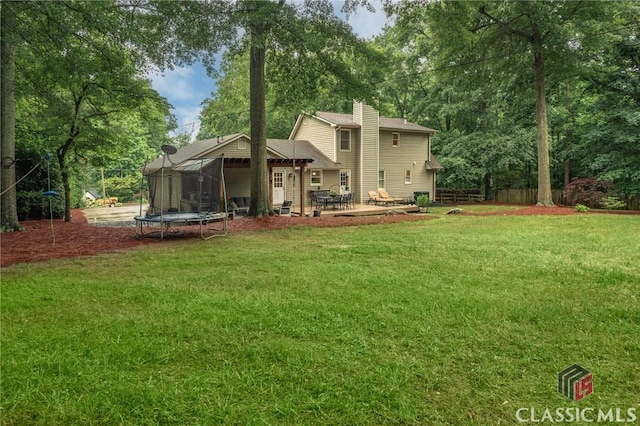 4080 Derby, Cumming, GA 30040 - back of property featuring a trampoline, a chimney, a yard, and a patio area