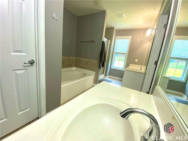 1100 Roberta Dr, Bishop, GA 30621 - bathroom with a garden tub, vanity, and baseboards