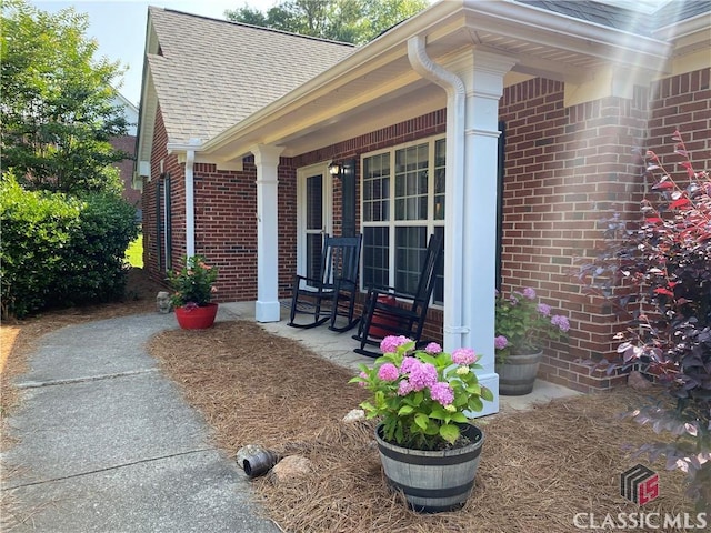 1100 Roberta Dr, Bishop, GA 30621 - view of side of home featuring brick siding, a shingled roof, and covered porch