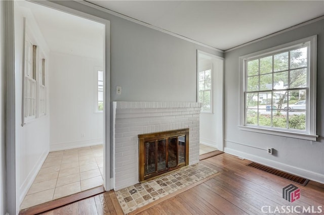 170 Stanton, Athens, GA 30606 - unfurnished living room featuring baseboards, hardwood / wood-style flooring, a fireplace, and crown molding