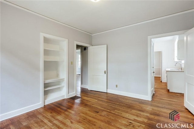 170 Stanton, Athens, GA 30606 - unfurnished bedroom with a sink, wood finished floors, baseboards, and crown molding