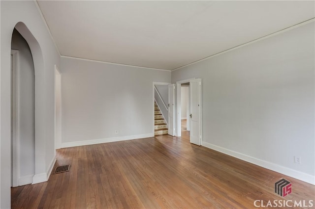 170 Stanton, Athens, GA 30606 - unfurnished room with hardwood / wood-style floors, baseboards, arched walkways, stairway, and ornamental molding