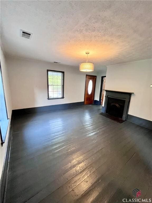 180 N Poplar St, Athens, GA 30601 - unfurnished living room featuring dark wood-style flooring, baseboards, a textured ceiling, and a fireplace with flush hearth