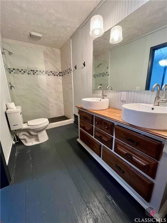 180 N Poplar St, Athens, GA 30601 - bathroom with a textured ceiling, double vanity, a tile shower, wood-type flooring, and toilet