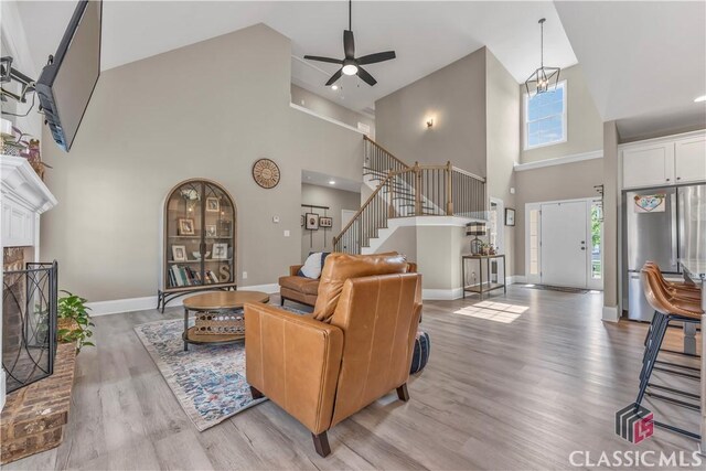 1810 Willow Creek Dr, Watkinsville, GA 30677 - living area featuring high vaulted ceiling, ceiling fan, stairs, light wood-type flooring, and baseboards
