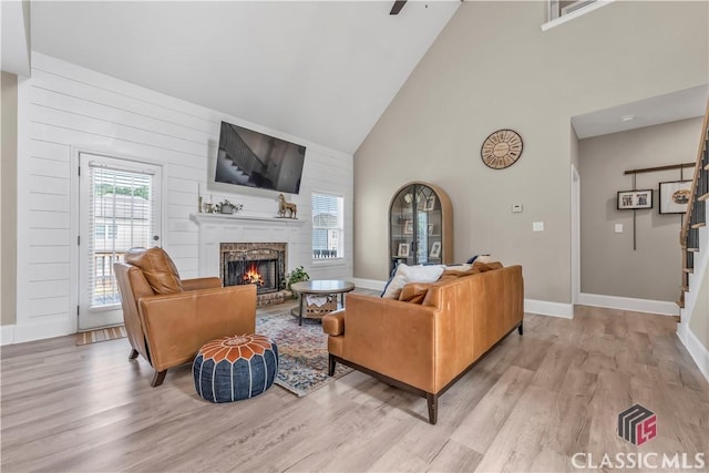 1810 Willow Creek Dr, Watkinsville, GA 30677 - living area featuring high vaulted ceiling, stairs, light wood-style floors, a fireplace, and baseboards