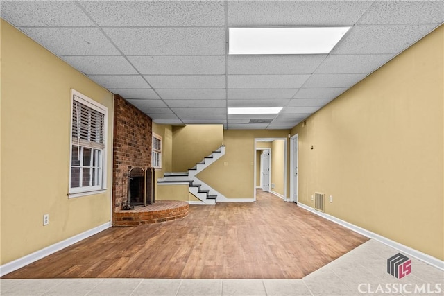 161 Pinecrest Ter, Athens, GA 30606 - unfurnished living room featuring a drop ceiling, wood finished floors, stairway, a fireplace, and baseboards
