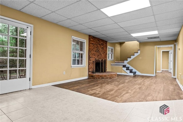 161 Pinecrest Ter, Athens, GA 30606 - unfurnished living room with a fireplace, wood finished floors, a paneled ceiling, baseboards, and stairway