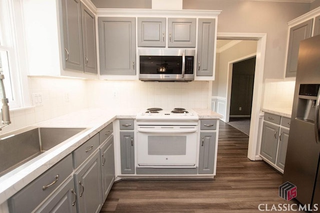 1851 Harvest Way, Loganville, GA 30052 - kitchen with appliances with stainless steel finishes, gray cabinets, backsplash, dark wood finished floors, and light countertops