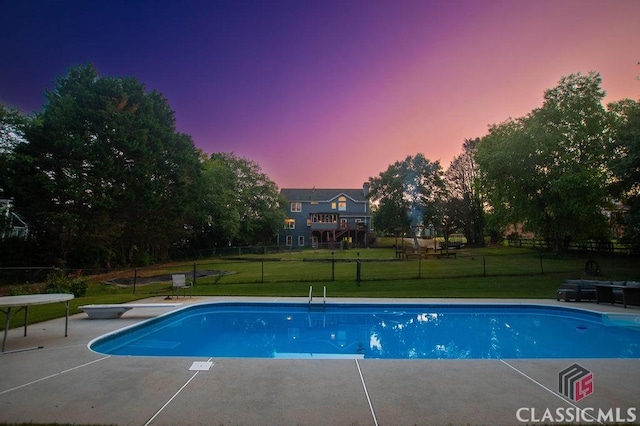1851 Harvest Way, Loganville, GA 30052 - pool at dusk featuring a diving board, an outdoor pool, and a patio area