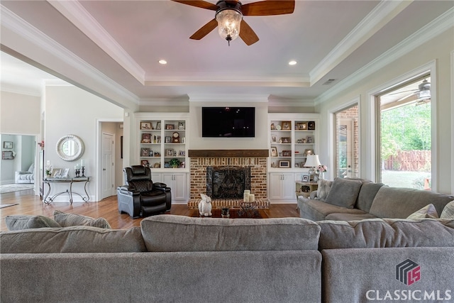 1641 Lane Creek Rd, Bogart, GA 30622 - living room with a tray ceiling, wood finished floors, a ceiling fan, a fireplace, and crown molding
