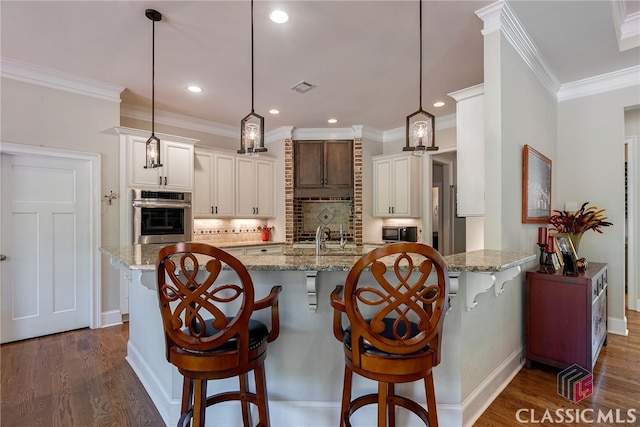 1641 Lane Creek Rd, Bogart, GA 30622 - kitchen featuring stainless steel oven, decorative backsplash, a breakfast bar area, dark wood-type flooring, and ornamental molding