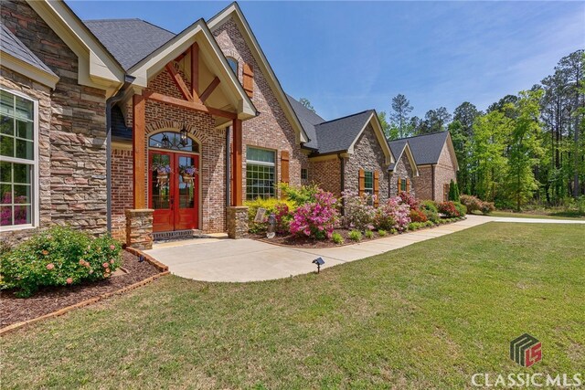 1641 Lane Creek Rd, Bogart, GA 30622 - view of front of house with french doors, stone siding, a front yard, brick siding, and a shingled roof