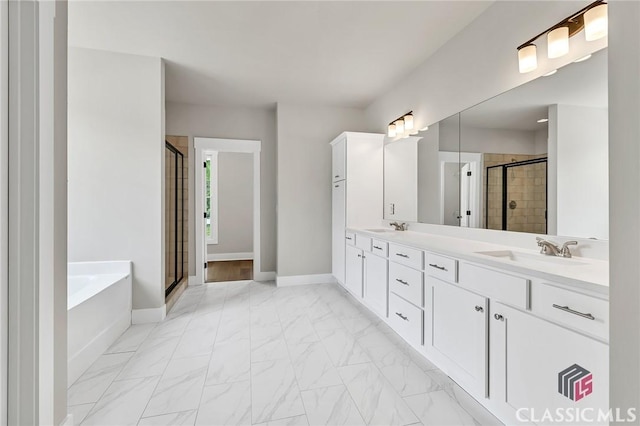 231 Marable St E, Monroe, GA 30655 - full bathroom featuring a shower stall, a bath, double vanity, marble look tile flooring, and baseboards