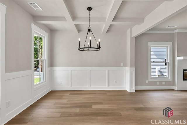 231 Marable St E, Monroe, GA 30655 - unfurnished dining area with coffered ceiling, a chandelier, light wood-type flooring, beamed ceiling, and wainscoting