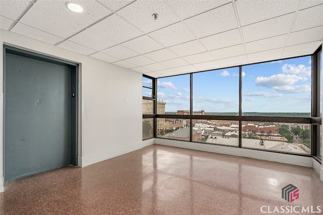 131 E Broad St Unit 506, Athens, GA 30601 - empty room featuring floor to ceiling windows, baseboards, a drop ceiling, fire sprinkler in ceiling, and speckle patterned floor