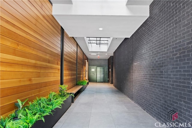 131 E Broad St Unit 506, Athens, GA 30601 - hall featuring light tile patterned flooring and brick wall