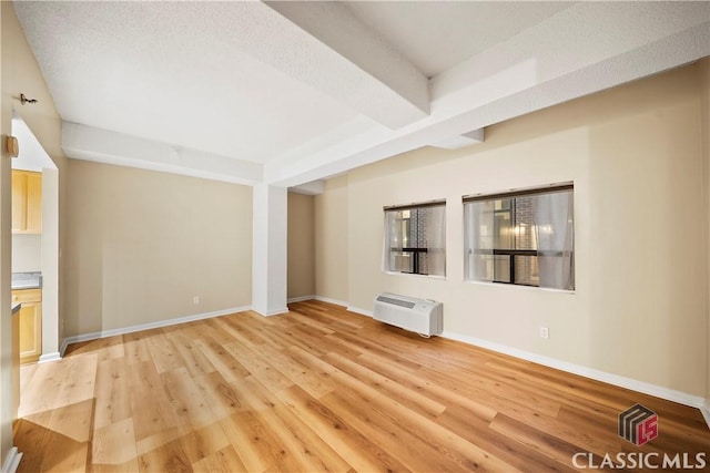 131 E Broad St Unit 506, Athens, GA 30601 - unfurnished living room with light wood-style flooring, baseboards, and an AC wall unit