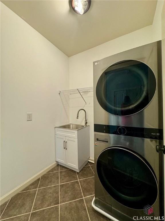 64 Charter Oak Dr, Athens, GA 30607 - laundry area with stacked washer and clothes dryer, baseboards, dark tile patterned floors, and cabinet space