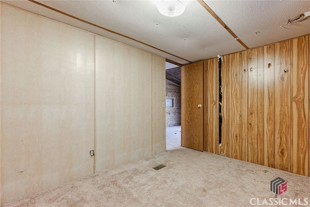 1200 Burr Harris Rd, Watkinsville, GA 30677 - carpeted spare room with a textured ceiling and wood walls