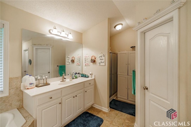 1663 Oconee Pt, Jefferson, GA 30549 - full bathroom featuring vanity, a shower stall, a bath, tile patterned floors, and a textured ceiling