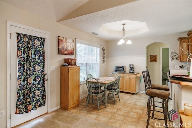 1663 Oconee Pt, Jefferson, GA 30549 - dining space featuring a tray ceiling, arched walkways, baseboards, and a textured ceiling