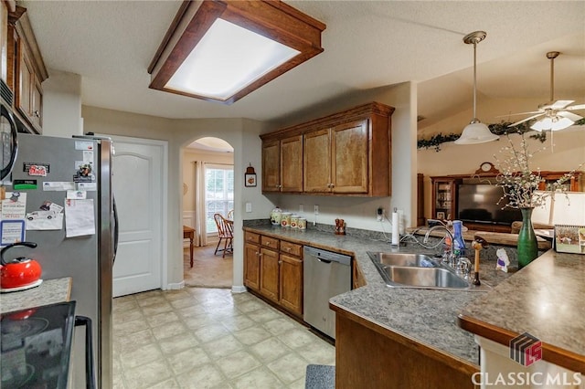 1663 Oconee Pt, Jefferson, GA 30549 - kitchen with stainless steel appliances, a sink, arched walkways, light flooring, and brown cabinetry