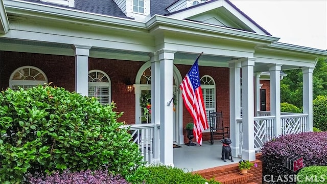 305 Calumet Ln, Monroe, GA 30655 - doorway to property with covered porch, brick siding, and a shingled roof
