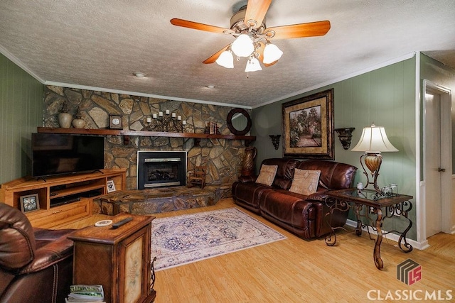226 Baker St, Statham, GA 30666 - living area featuring ornamental molding, a textured ceiling, wood finished floors, ceiling fan, and a fireplace