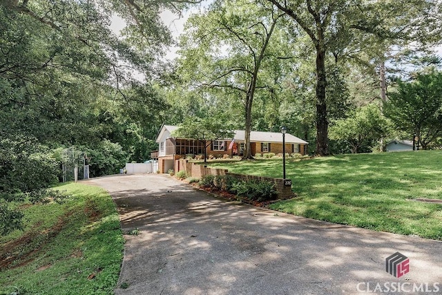 226 Baker St, Statham, GA 30666 - view of front of home with asphalt driveway, a front lawn, and a forest view