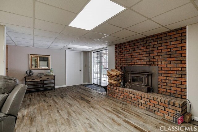 226 Baker St, Statham, GA 30666 - unfurnished living room featuring wood finished floors, a paneled ceiling, and a wood stove