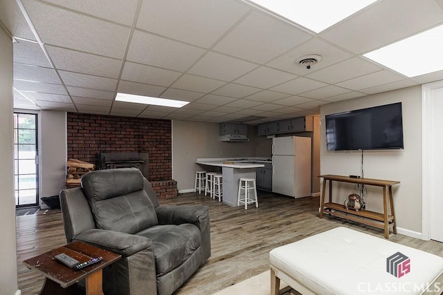 226 Baker St, Statham, GA 30666 - living area featuring light wood-type flooring, a brick fireplace, and a drop ceiling