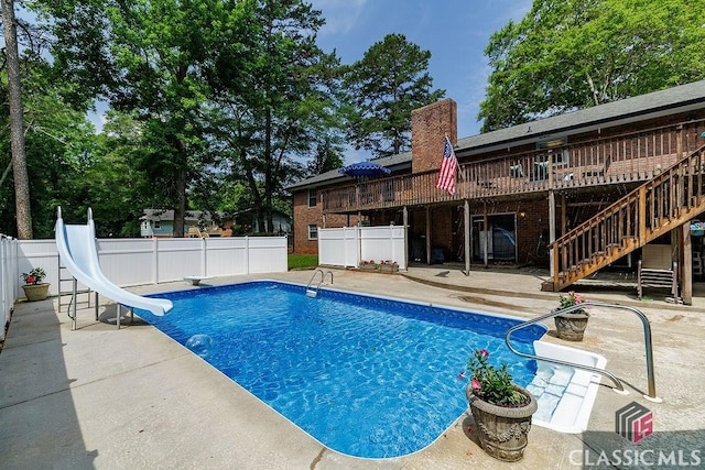 226 Baker St, Statham, GA 30666 - view of swimming pool featuring a water slide, a patio area, stairway, a fenced backyard, and a wooden deck