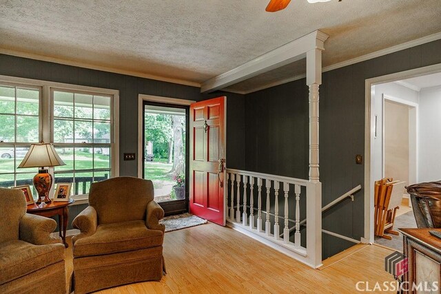 226 Baker St, Statham, GA 30666 - living area with light wood-style floors, an upstairs landing, crown molding, a textured ceiling, and ceiling fan