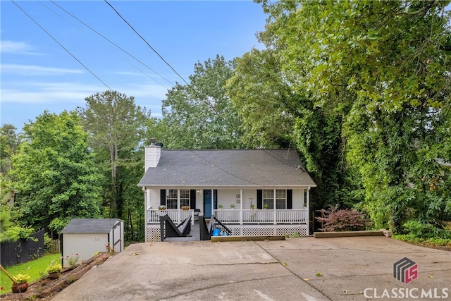5480 Apache Trl, Gainesville, GA 30506 - view of front of house with covered porch, a chimney, a shed, driveway, and roof with shingles