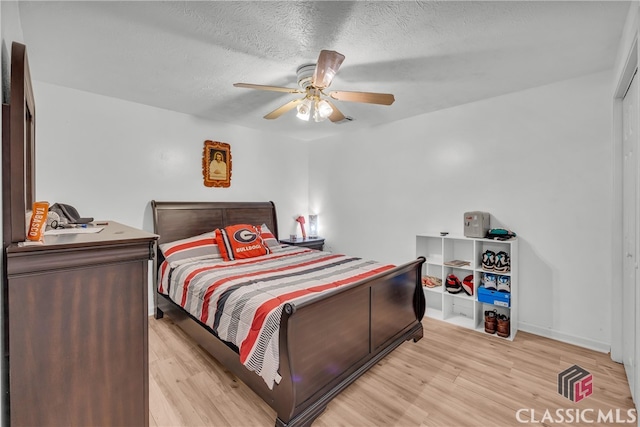 5480 Apache Trl, Gainesville, GA 30506 - bedroom featuring light wood-style flooring, a textured ceiling, and ceiling fan
