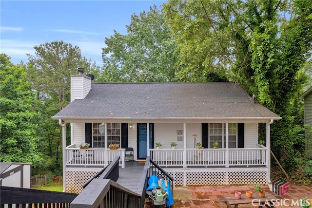 5480 Apache Trl, Gainesville, GA 30506 - view of front of house featuring a porch, a chimney, and roof with shingles