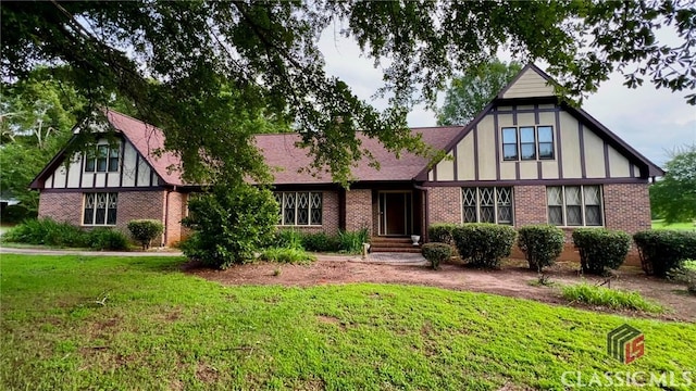 186 Kingston Rd, Colbert, GA 30628 - tudor house featuring brick siding, a front lawn, and a chimney